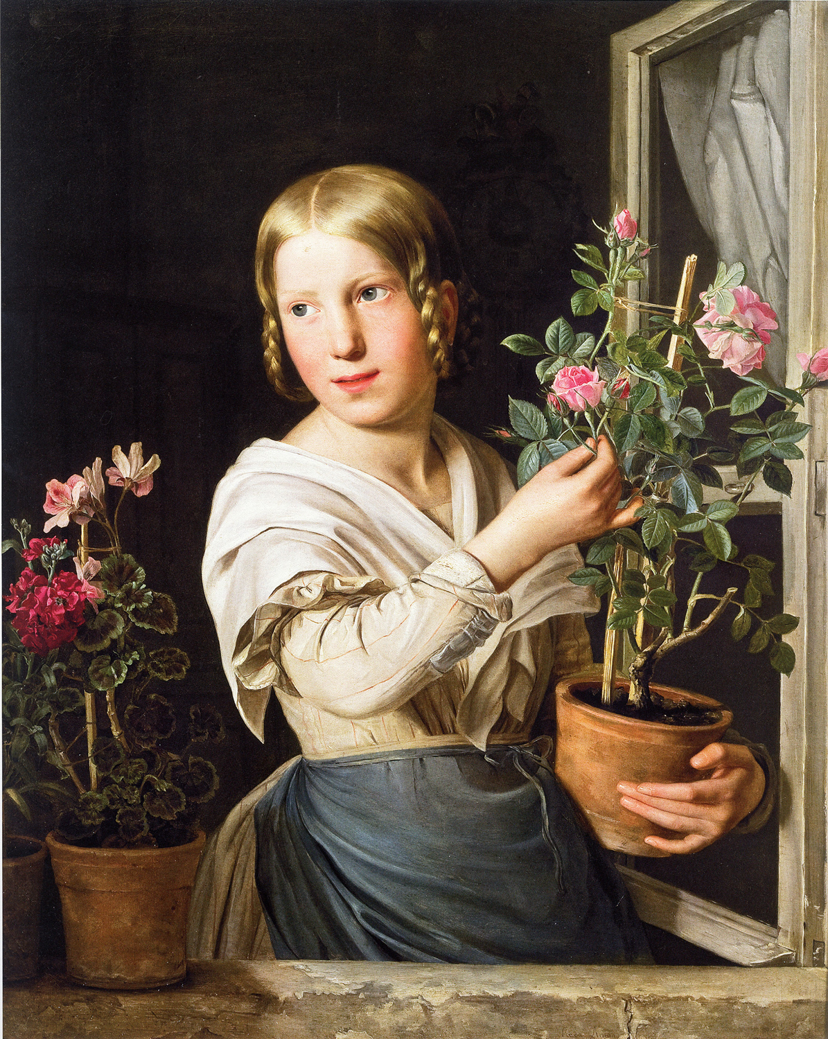 Junges blondes Mädchen in weißer Bluse vor einem Fenster und Blumenstock in der Hand