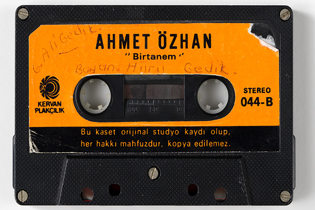 Orange Hörkasette mit der Aufschrift Ahemt Özhan und handschriftlichen Notizen