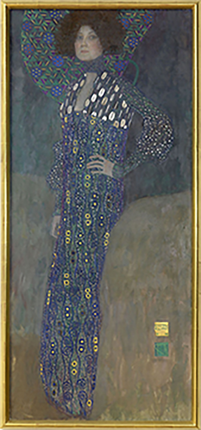 Bildnis von Emilie Flöge in einem lila gemusterten Kleid mit goldigen und weißen Akzenten, Muster ziert auch den Hintergrund der lockigen Haare 