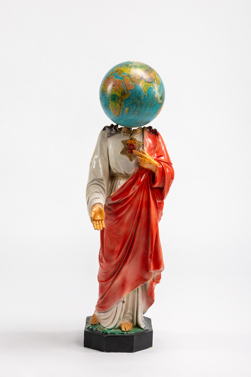 Eine Christusfigur dessen Kopf ein Globus ist