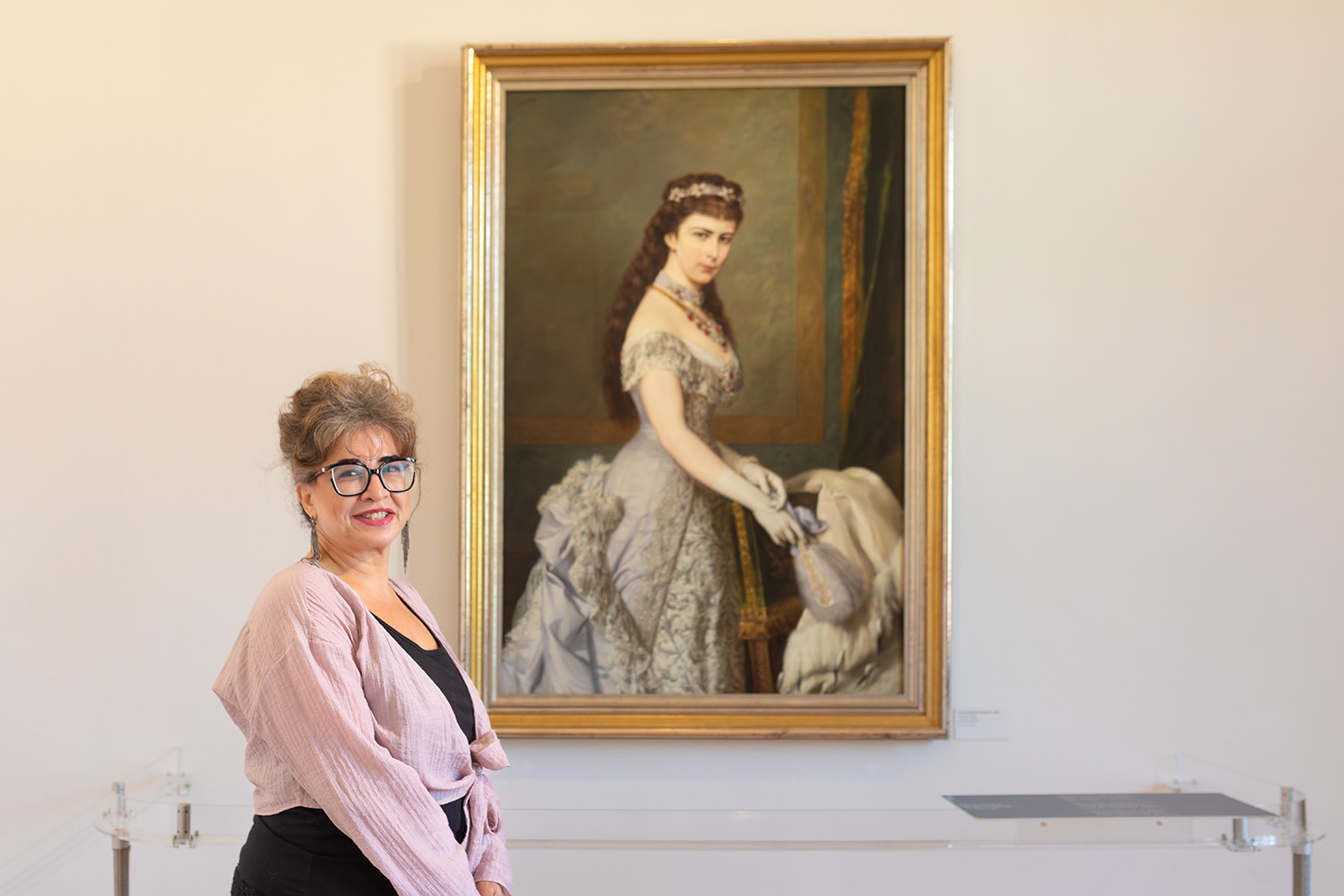 Frau steht vor einem Porträt der Kaiserin Sisi