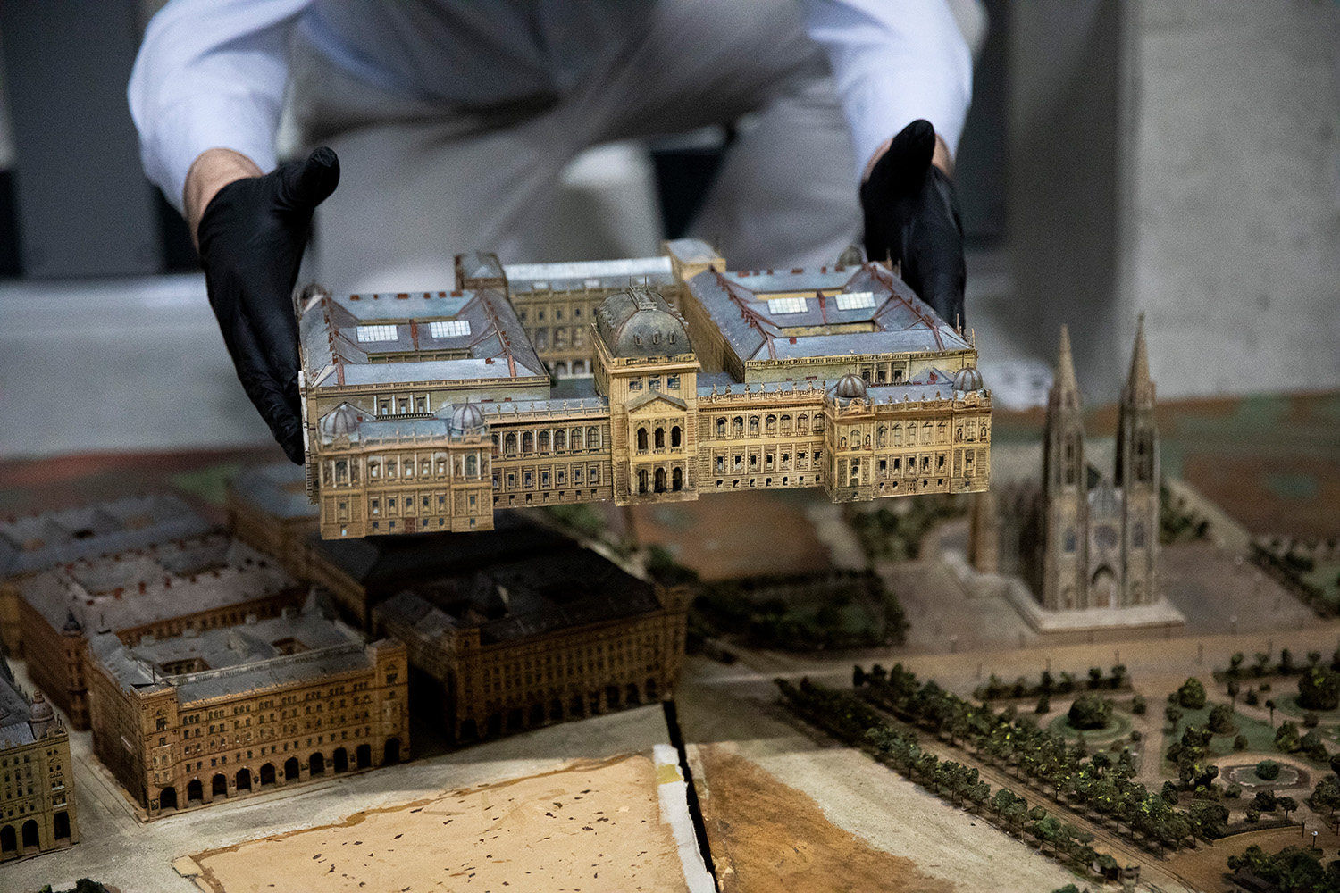 Das Modell der Universität Wien wird angebracht, im Hintergrund ist die Votivkirche zu sehen