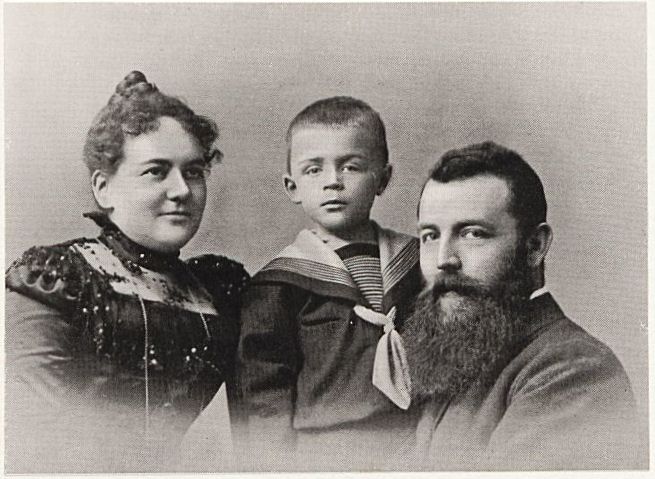 Familienporträt in schwarz-weiß, Mutter links, Vater rechts und Kind in der Mitte.