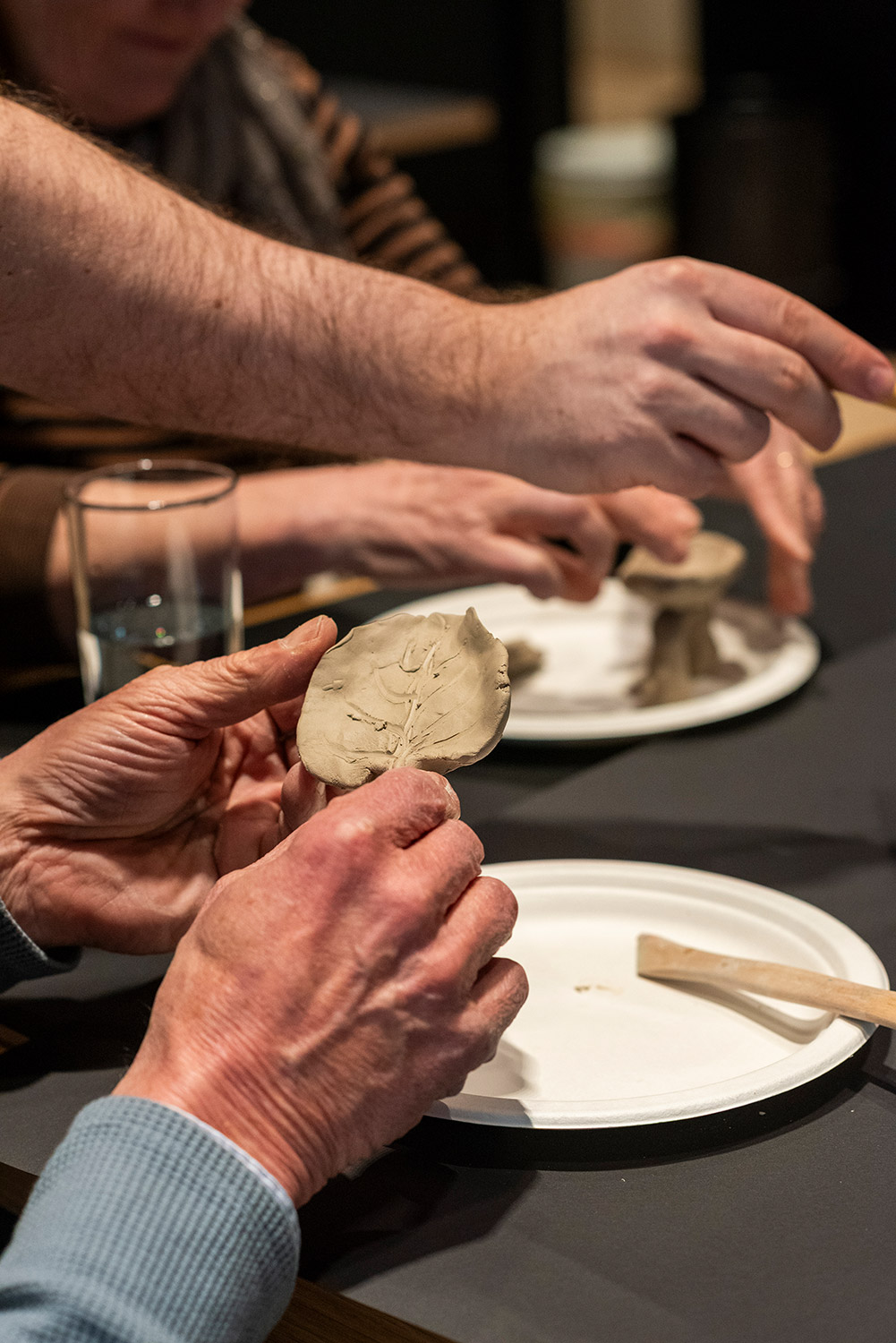 Hände formen Ton bei Kreativworkshop