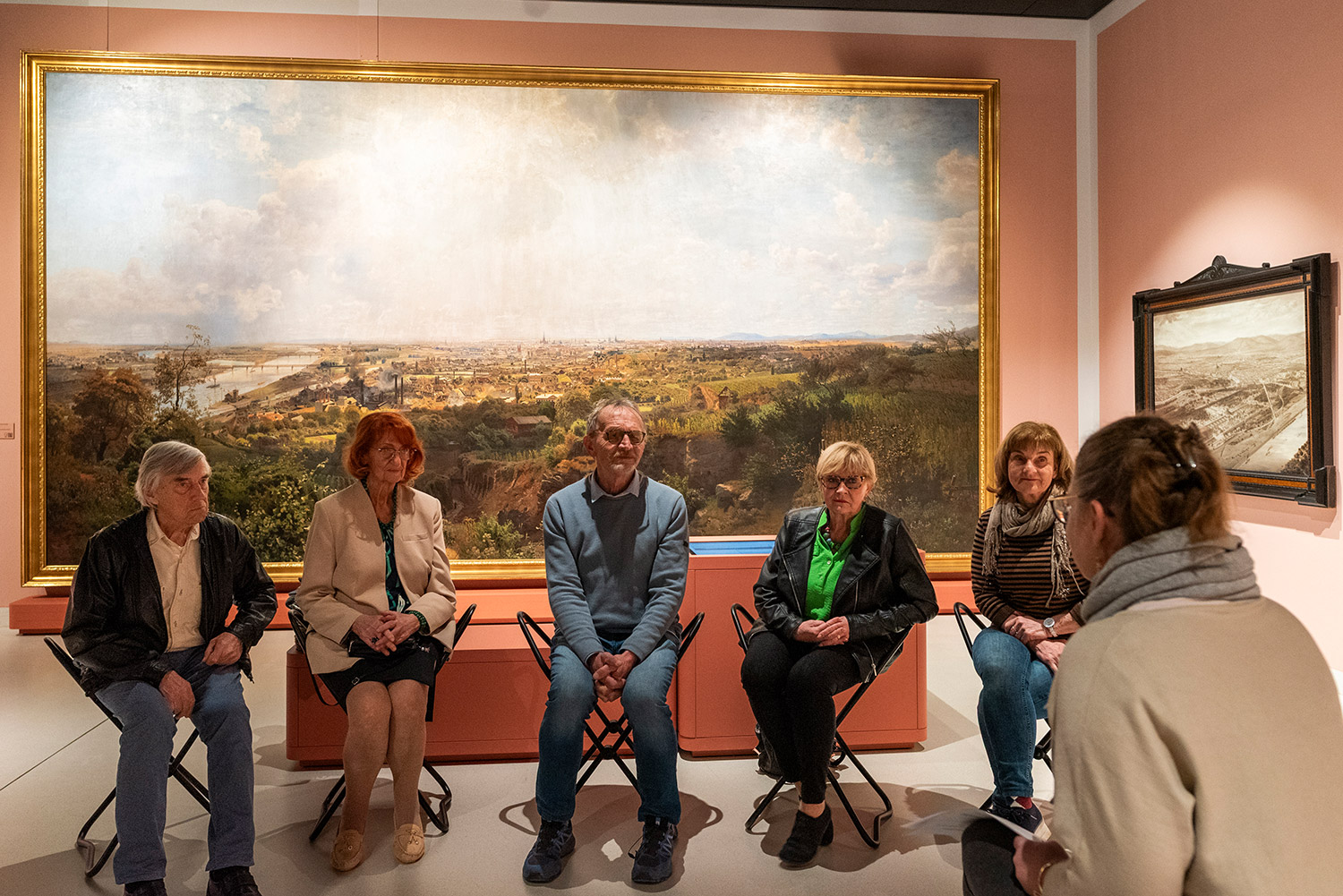 Seniorengruppe sitzt vor Gemälde im Wien Museum