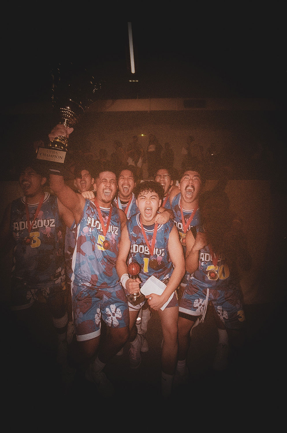 Eine Gruppe von Sportlern feiern einen Sieg mit Medaillen und Pokal
