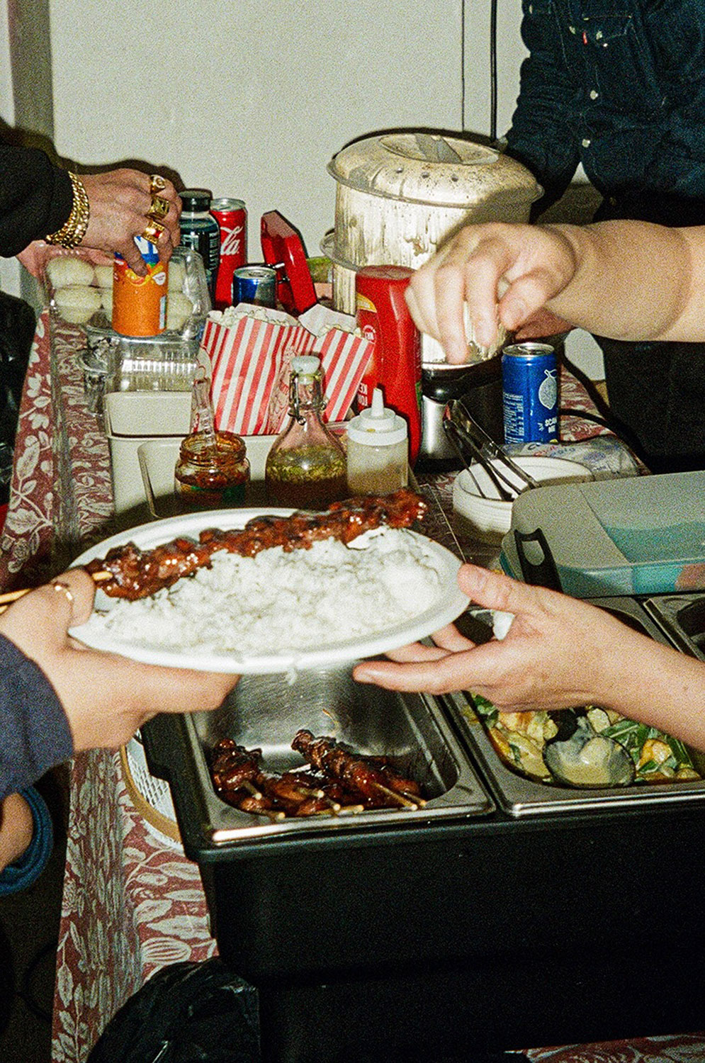 Essen auf einem Tisch und Hände die einen Teller halten 
