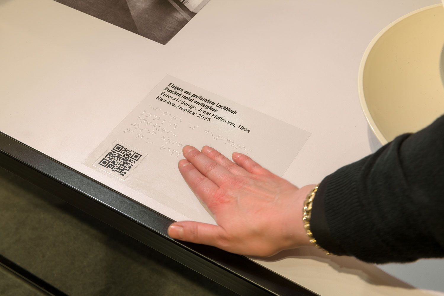 Hand auf einem Objekttext in Brailleschrift für ein taktiles Objekt