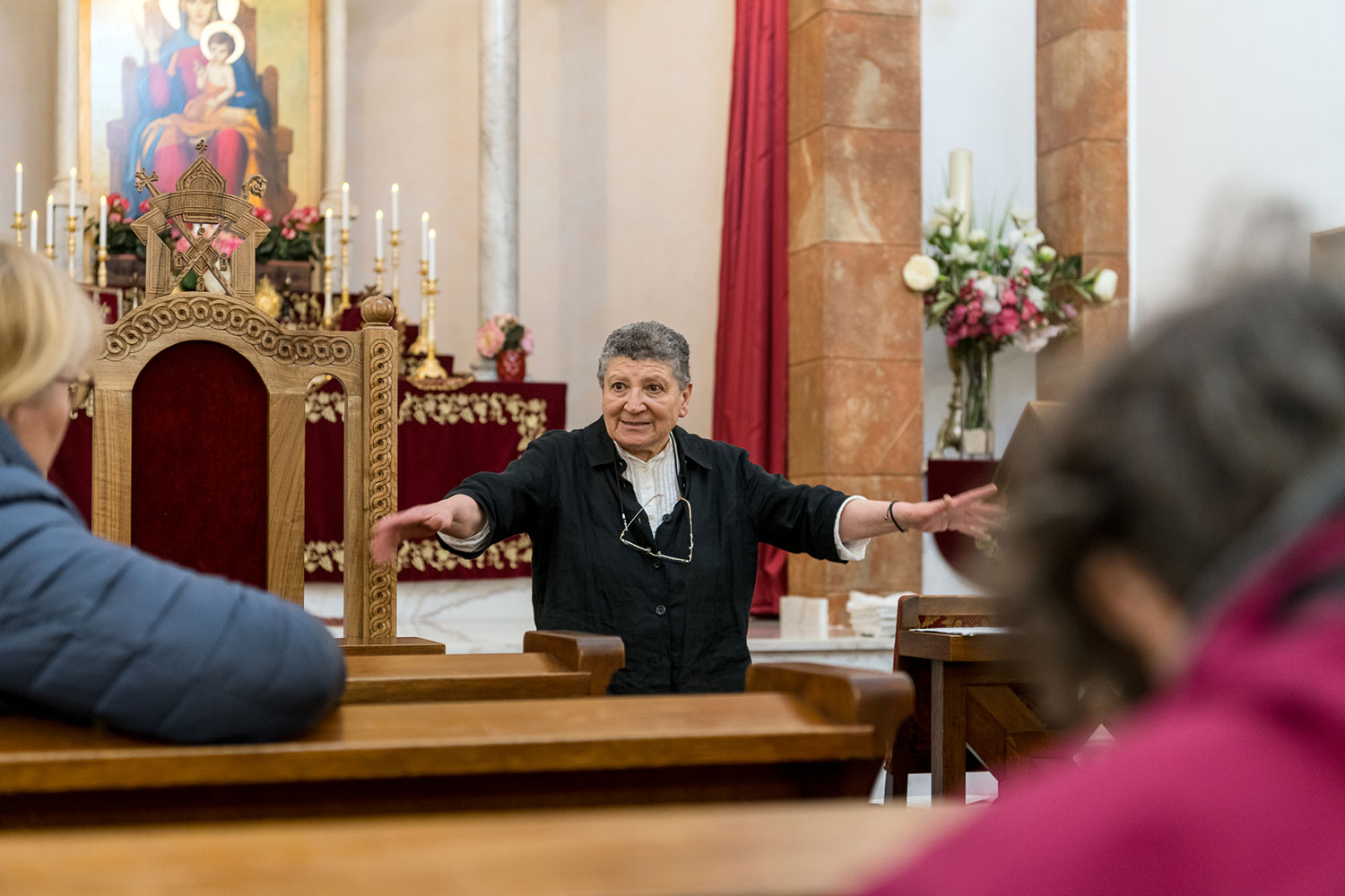 Eine Frau vorm Altar mit anderen Besuchern