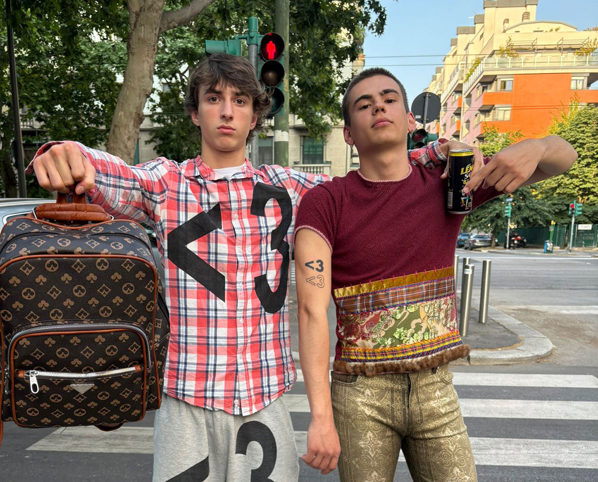Zwei Musiker auf einem Zebrastreifen mit Rucksack und Bierdose in der Hand