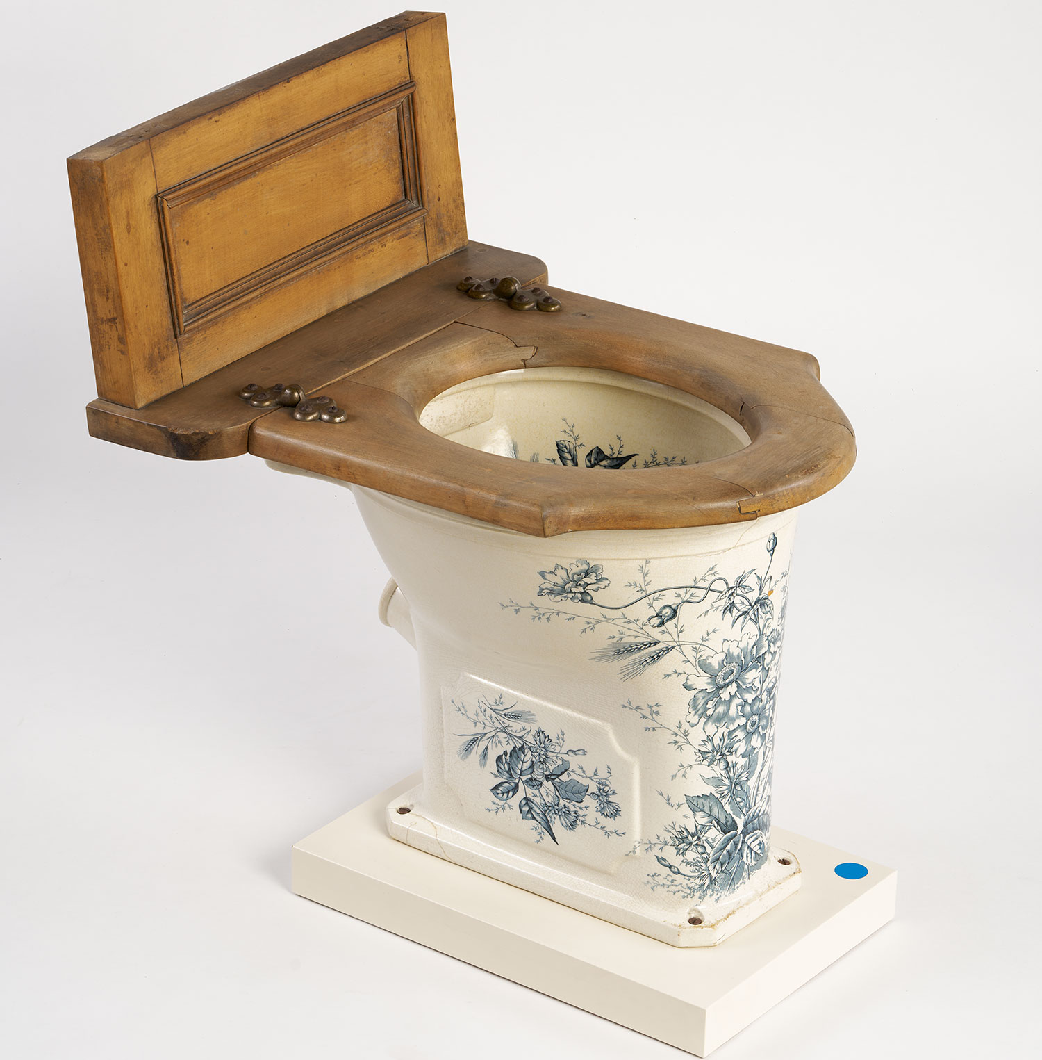 Weißes Wasserklosett mit blauen Blumenmuster und einem Holzsitz