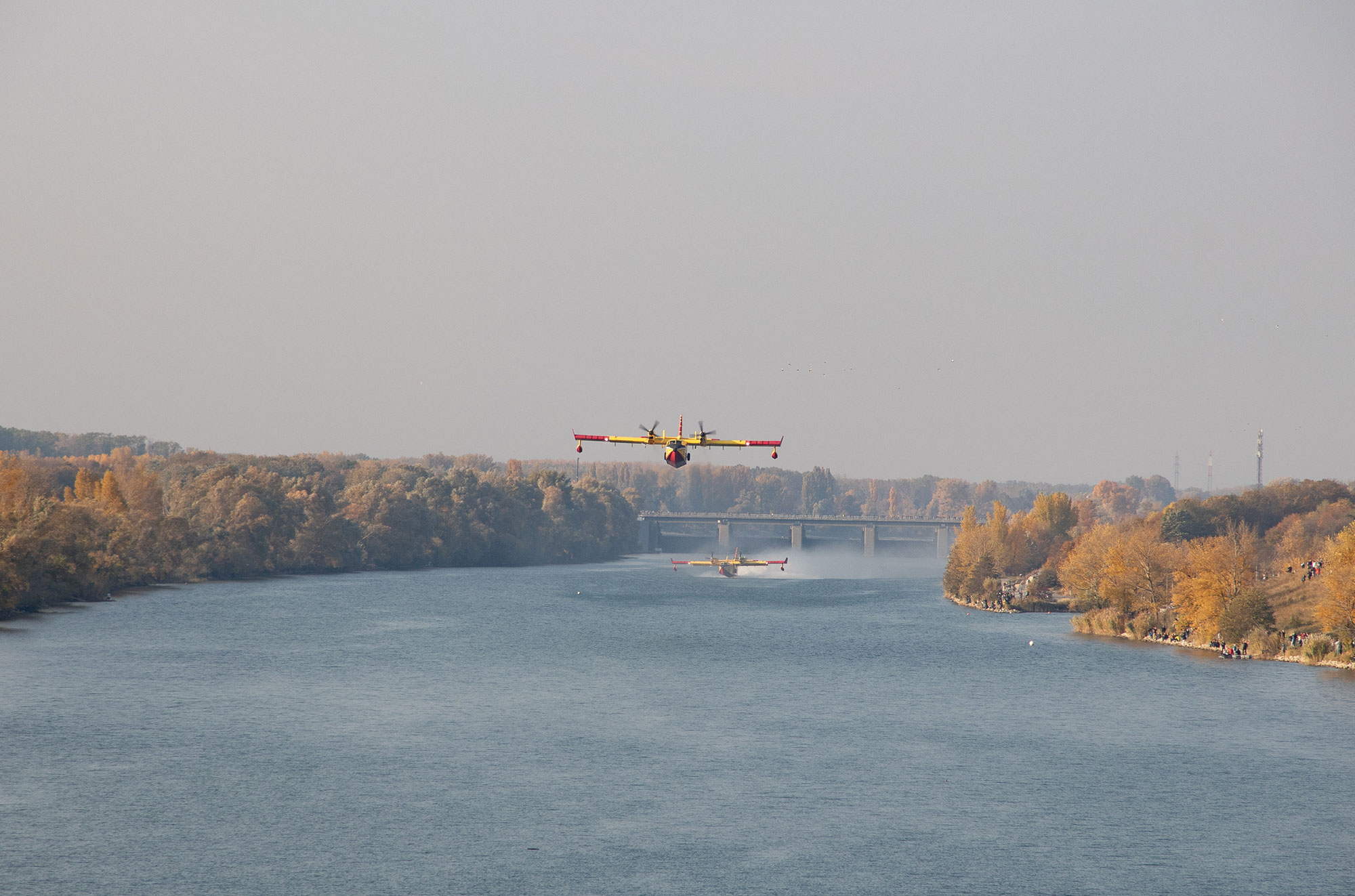 Zwei Löschflugzeuge, die Wasser auf der Donau aufnehmen