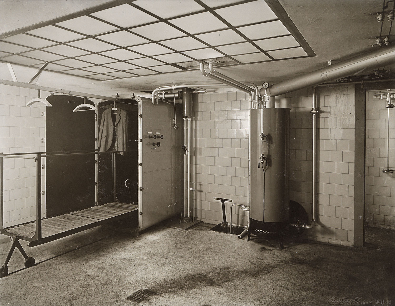 In einem gefliesten sterilen Raum sind verschiedene technische Vorrichtungen und eine Anzugjacke hängt an einem Kleiderhaken