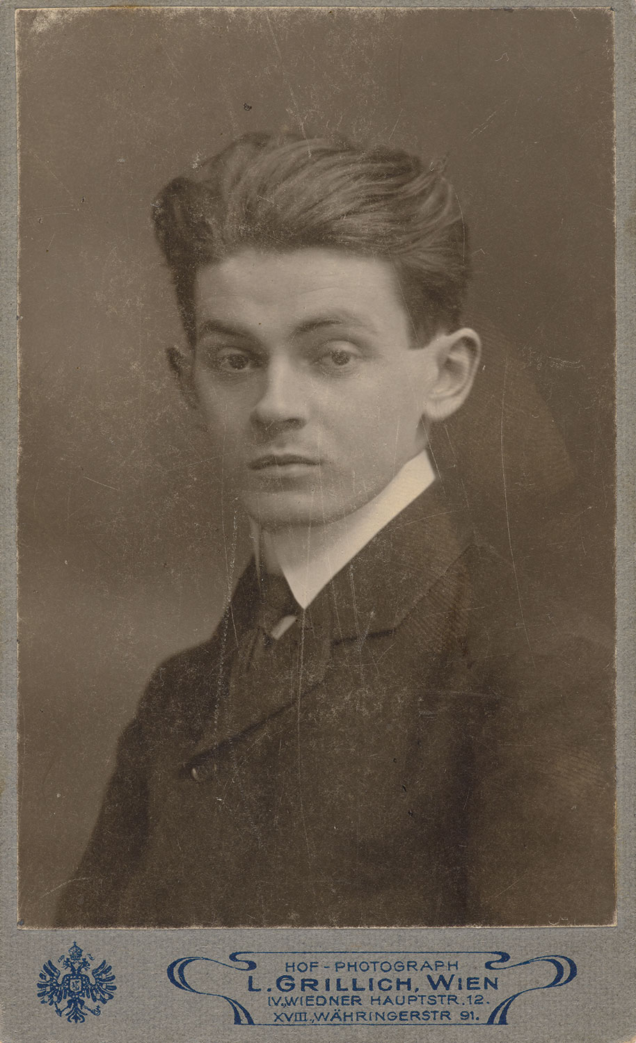 Junger Mann mit kurzen Haaren in Anzug und Krawatte 