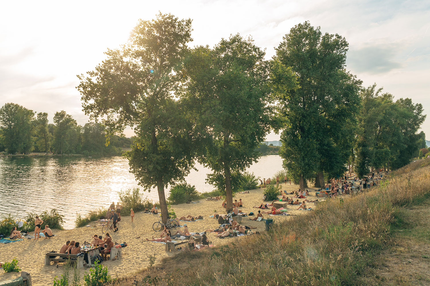 Viele sonnenbadende Personen auf dem Ufer