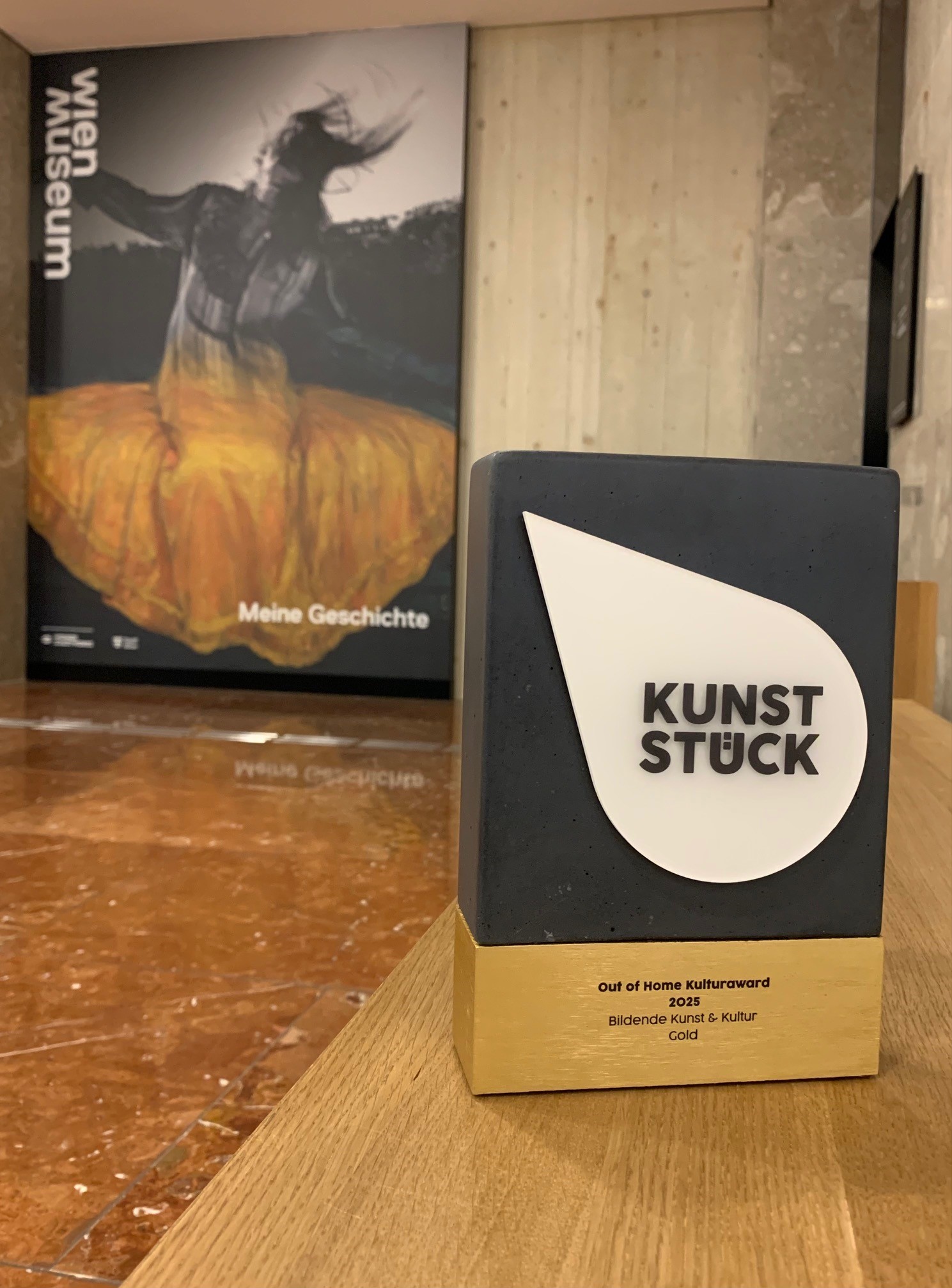 Die Preistrophäe im Eingangsbereich des Wien Museum vor dem Sieger-Sujet der Eröffnungskampagne.