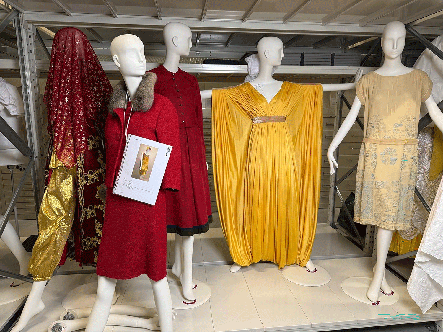 Drei Kleiderpuppen. Sie haben unterschiedliche Kleider. Die Kleider sind gelb und rot. Außerdem haben sie unterschiedliche Schnitte. 