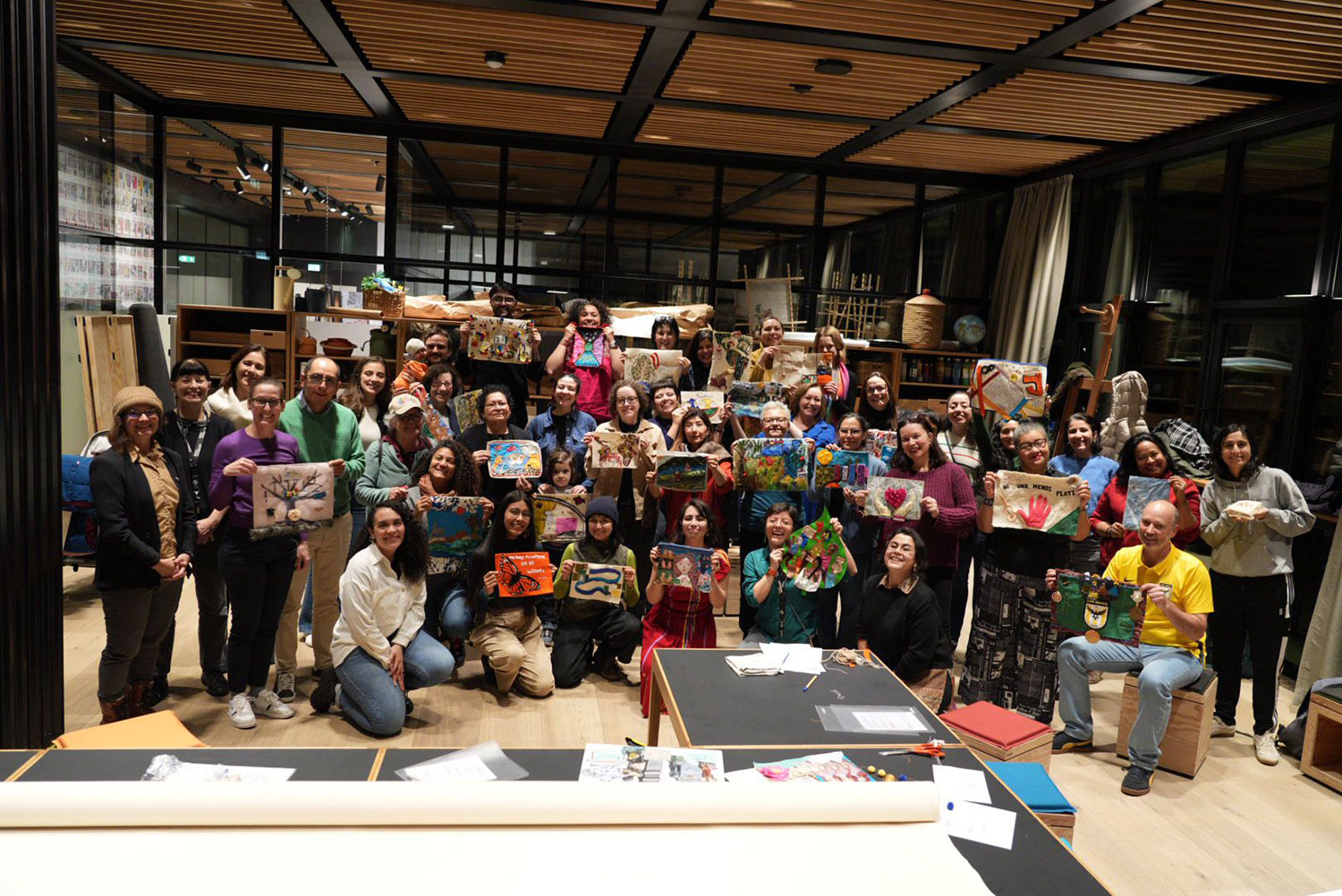 Viele Personen halten ihre Kunstwerke hoch und lächeln in die Kamera