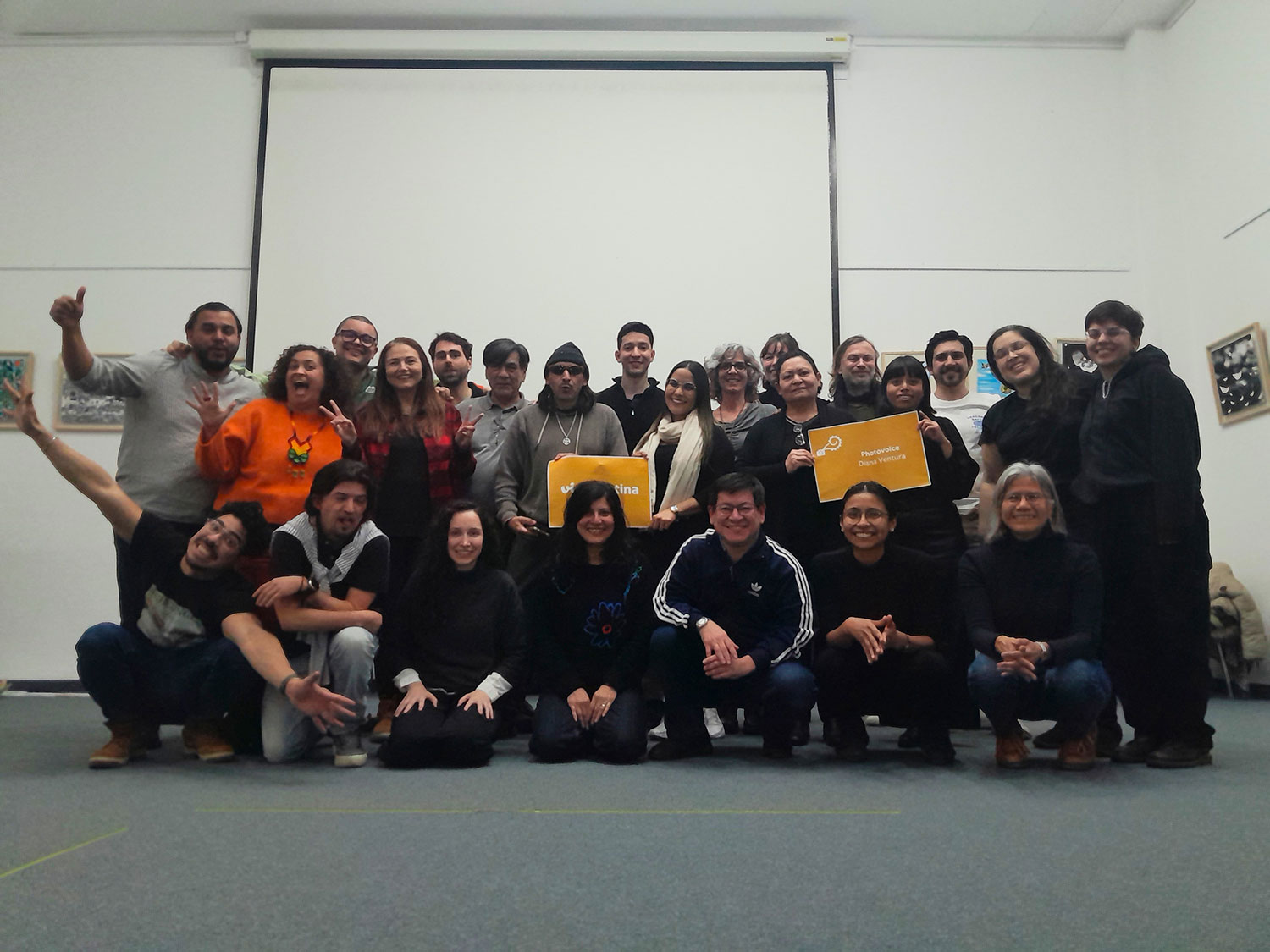 Viele Personen in drei Reihen hintereinander, manche halten Schilder