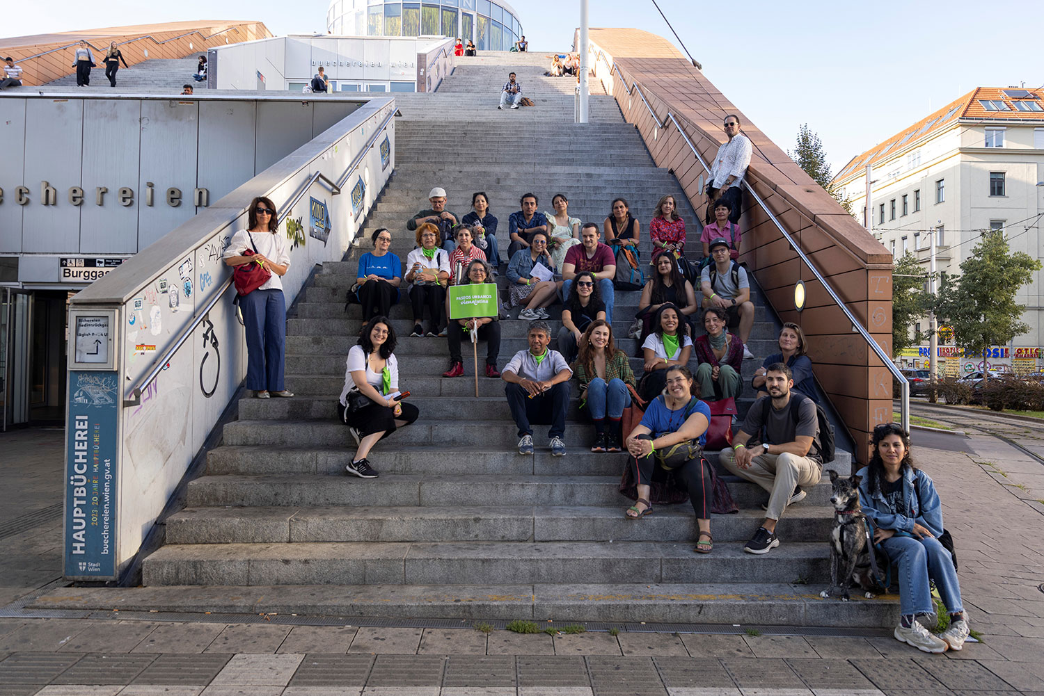 Viele Personen sitzen hintereinander auf einer Steintreppe