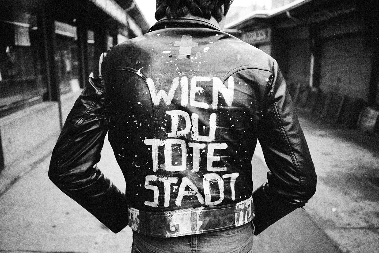 Mann von hinten mit einer Lederjacke auf der Wien du tote Stadt aufgemalt wurde