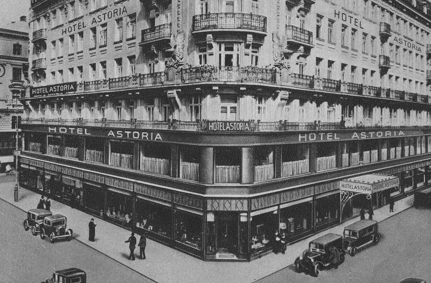 Hoteleingang von außen mit Straße, Menschen und Autos