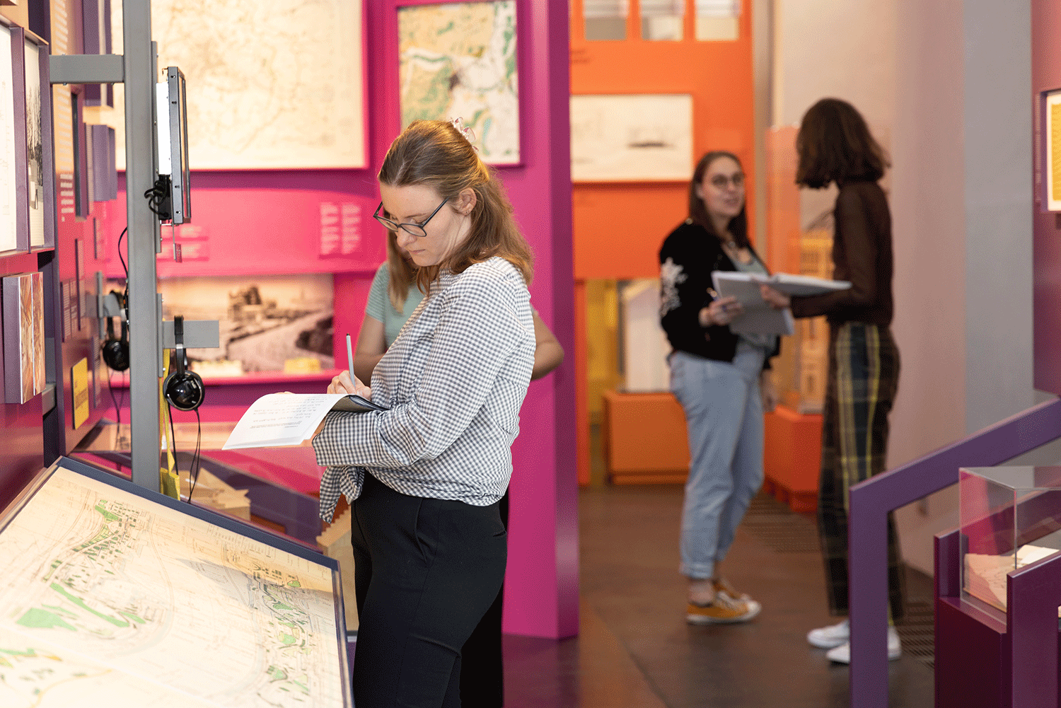 Drei Personen in einem Ausstellungsraum