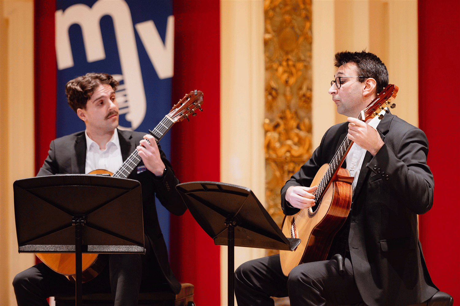 Zwei Musiker die auf einer Bühne Gitarre spielen