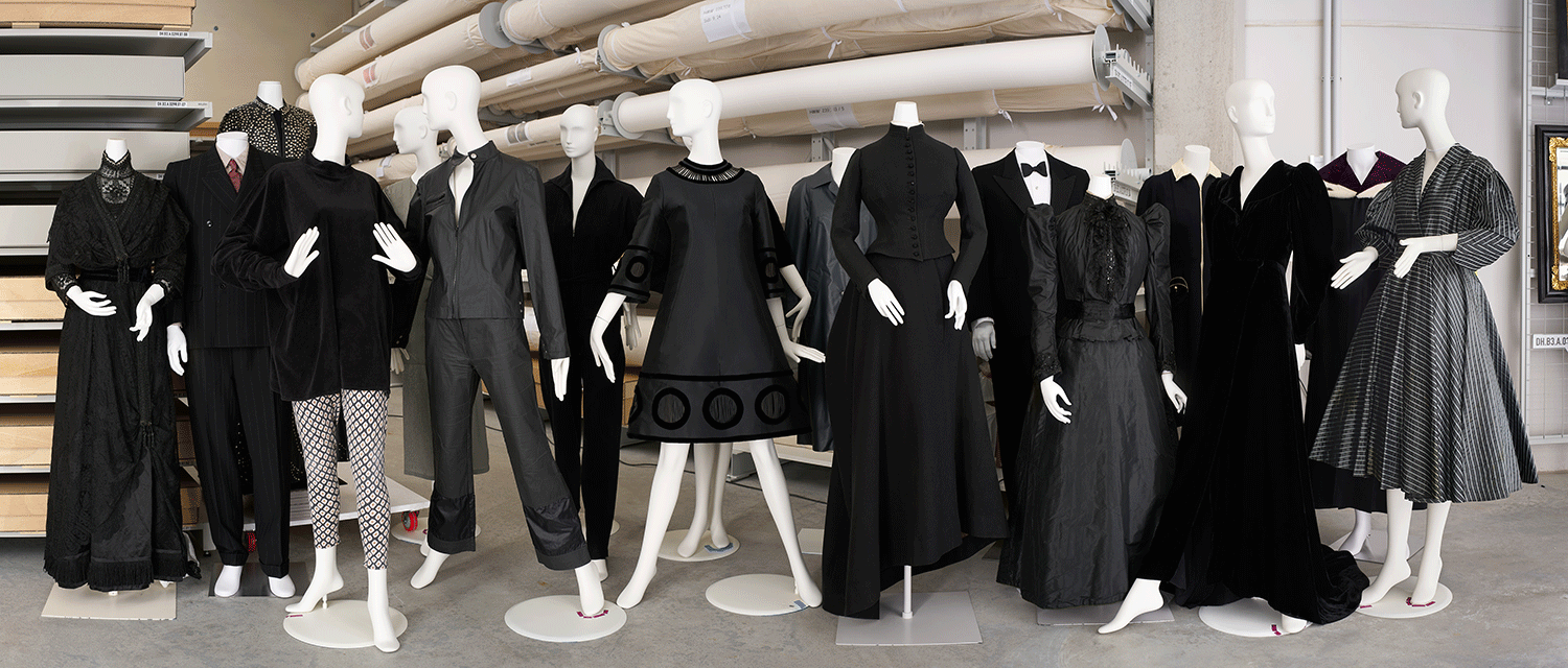 Viele unterschiedliche Modepuppen mit schwarzen Kleidern aus verschiedenen Jahrhunderten