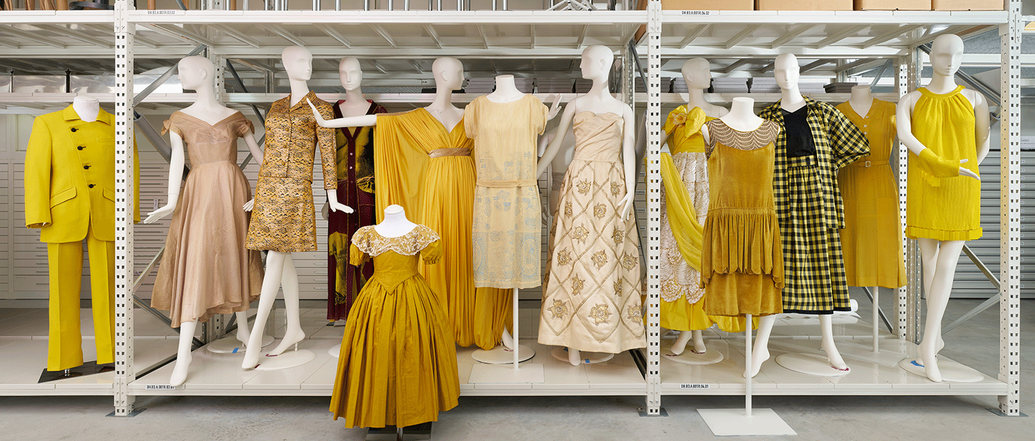 Viele unterschiedliche Modepuppen mit gelben Kleidern aus verschiedenen Jahrhunderten