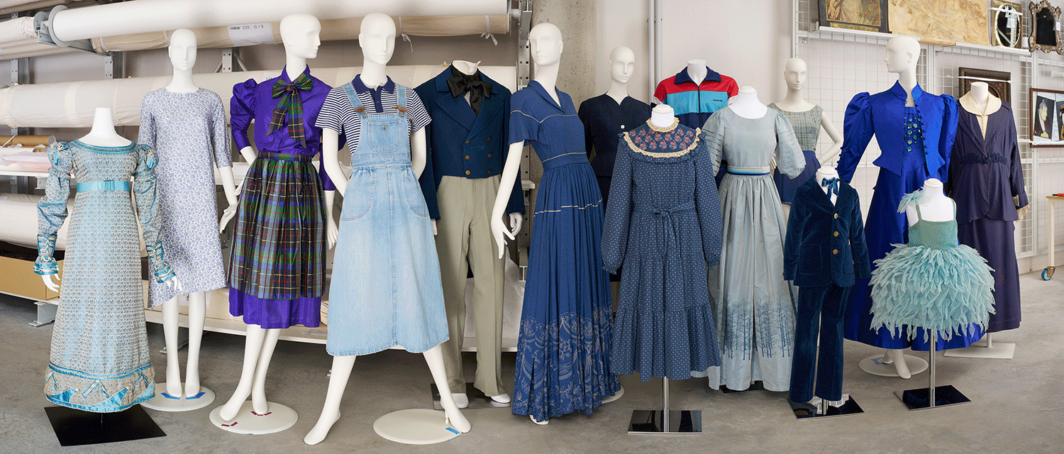 Viele unterschiedliche Modepuppen mit blauen Kleidern aus verschiedenen Jahrhunderten