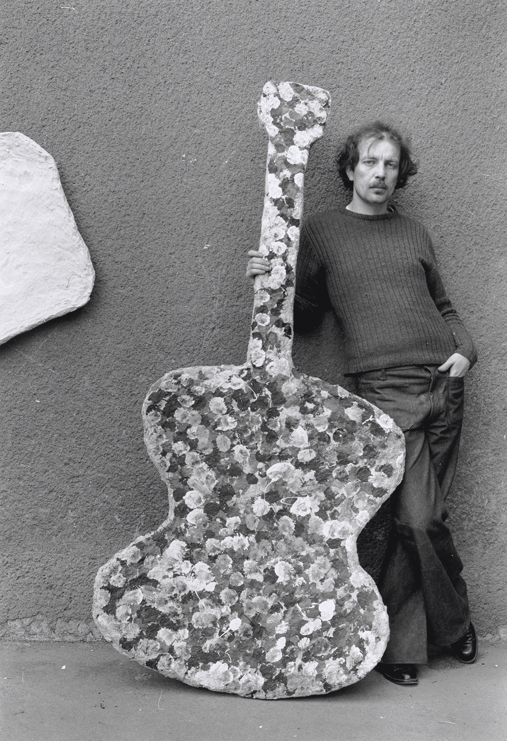 Künstler mit einem Kunstwerk in Form einer riesigen Gitarre 