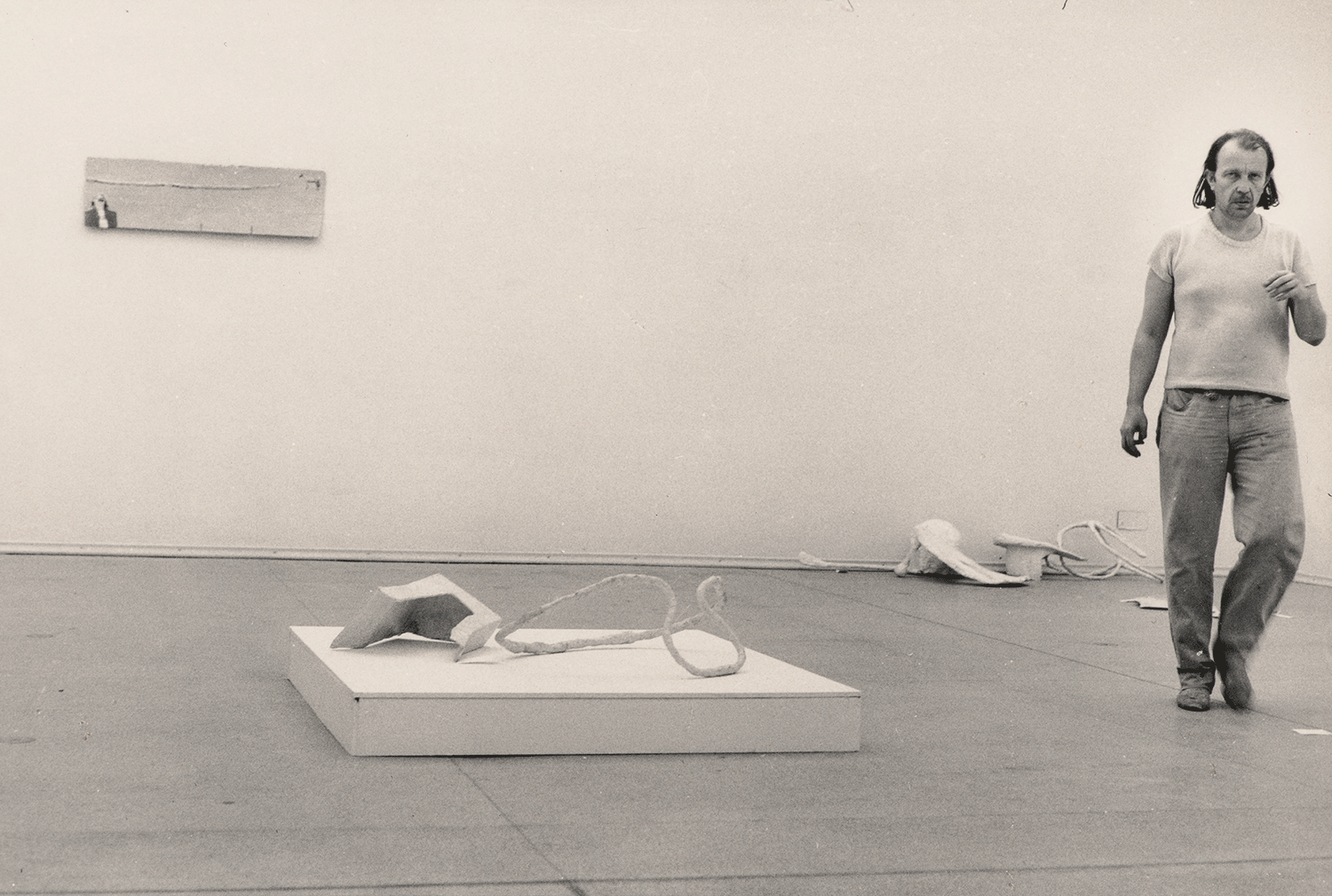Künstler geht zwischen den Kunstwerken im Ausstellungsraum 